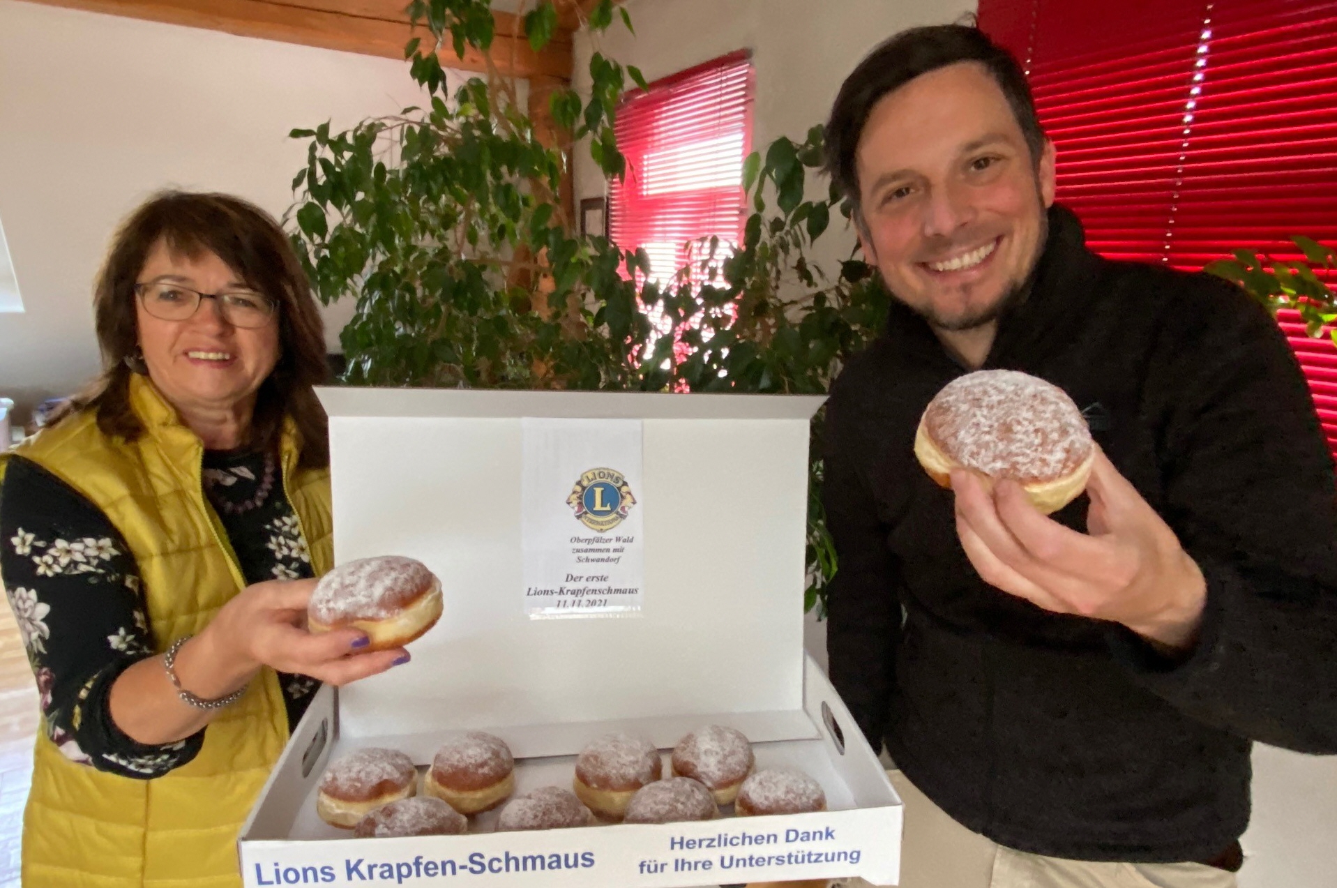 Zum reinbeißen: Die Präsidenten Maria Schlögl (Lions Oberpfälzer Wald) und Peter Mertins (Lions Schwandorf) machen Appetit auf den Krapfenschmaus.